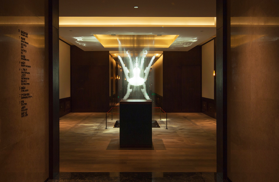 The design team presented the classic cultural relic "Bird-shaped Zun" unearthed in Bayu at the entrance of the Chinese restaurant with a modern aesthetic design. The lighting designer uses low-color-temperature diffuse light to create an ambient atmosphere, while using high-color-temperature lights to maximize the crystal clearness of this crystal artwork. At the same time, the bright light directed towards the artwork is deliberately avoided from the direction of approach of visitors. Bird shaped statue