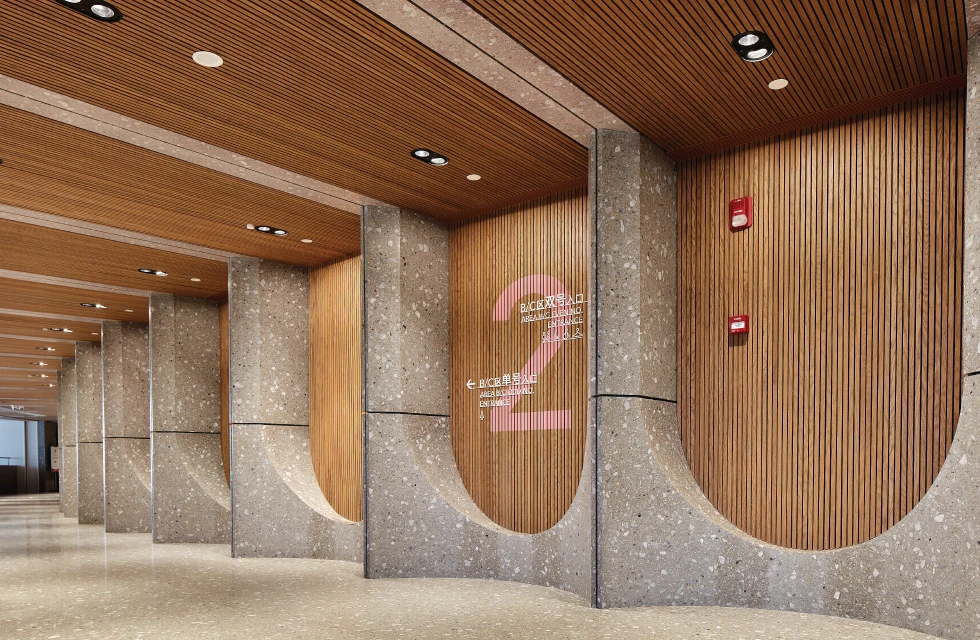 In the double-height arcade outside the grand theater, WAC specially customized two luminaires based on the original PLANA PRO downlight series for this project.
Installed along the corridor ceiling, the customized dual-head downlight integrates both downlighting and wall-washing functions into a single fixture. This solution not only fulfills the functional lighting requirements of the passageway, but also enhances the texture and material details of the walls through soft and uniform wall-washing illumination, creating a refined and elegant atmosphere. Customized PLANA PRO – Combining Downlighting and Wall Washing