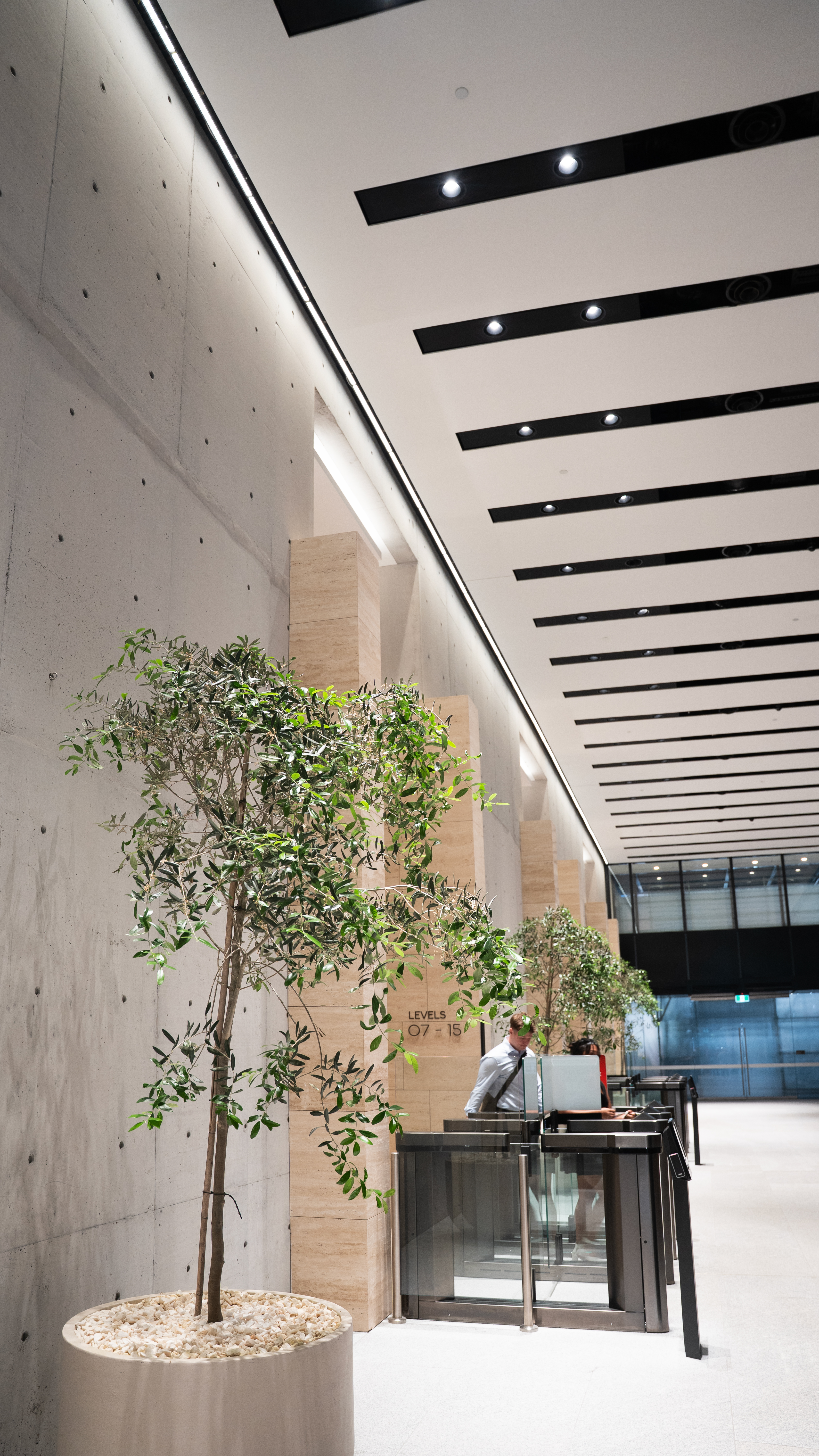 To achieve both spatial depth and functional illumination, **WAC Architectural selected the LIGNE Pro recessed linear downlight series** as the primary lighting solution for the lobby. In response to the unique ceiling channel design, a customized surface-mounted version was developed to seamlessly integrate within the existing ceiling structure.
Featuring high luminous efficacy, superior glare control, and a minimalist aesthetic, the luminaire delivers exceptional visual comfort while complementing the architectural language of the space. The refined design integrates discreetly into the ceiling, enhancing the overall ambiance while providing precise and efficient illumination throughout the lobby. Lobby